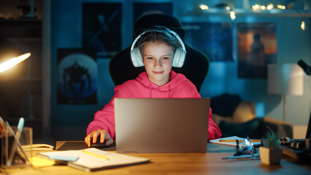 A young person in headphone using laptop computer.