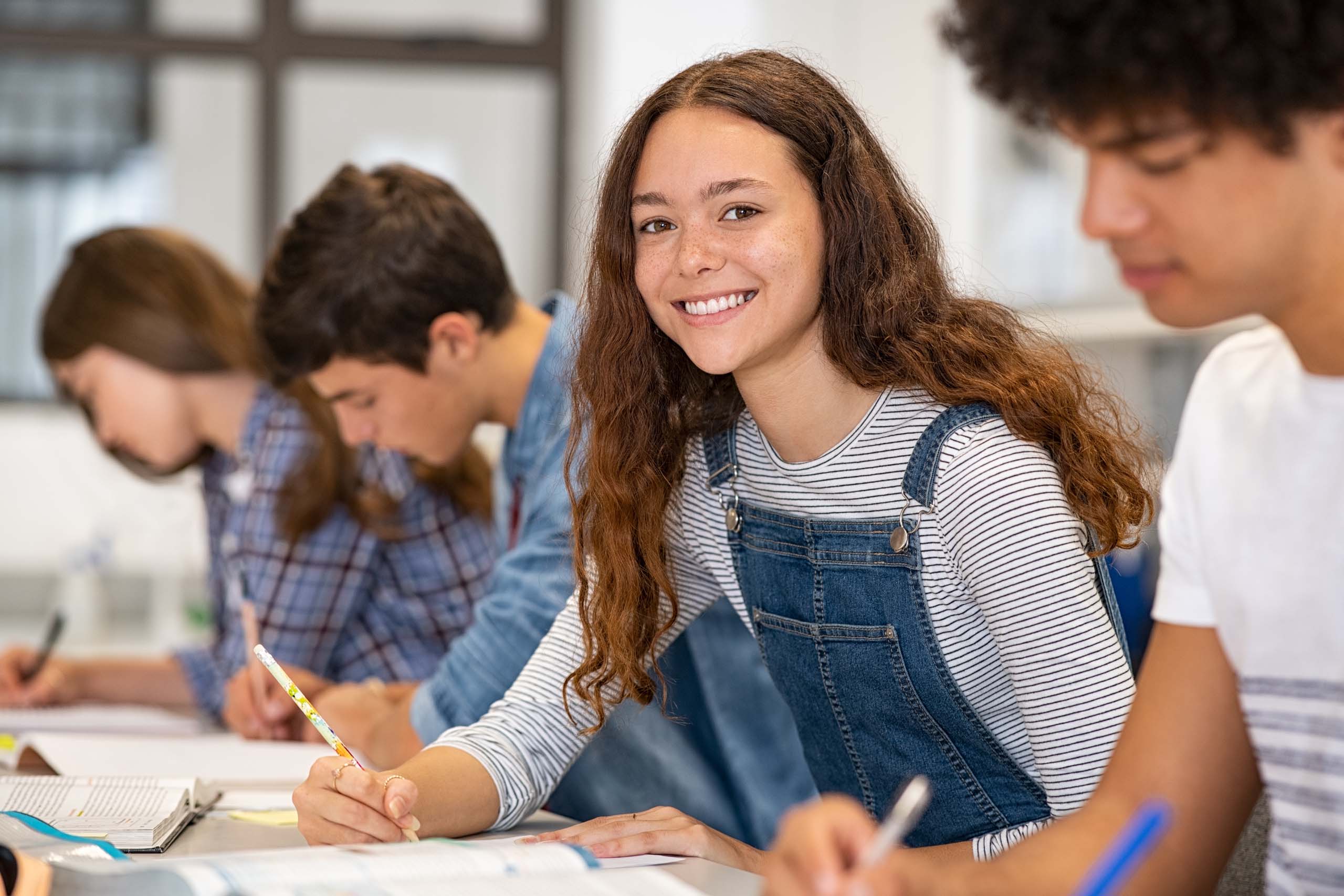 Young girl in a group study smile to camera
