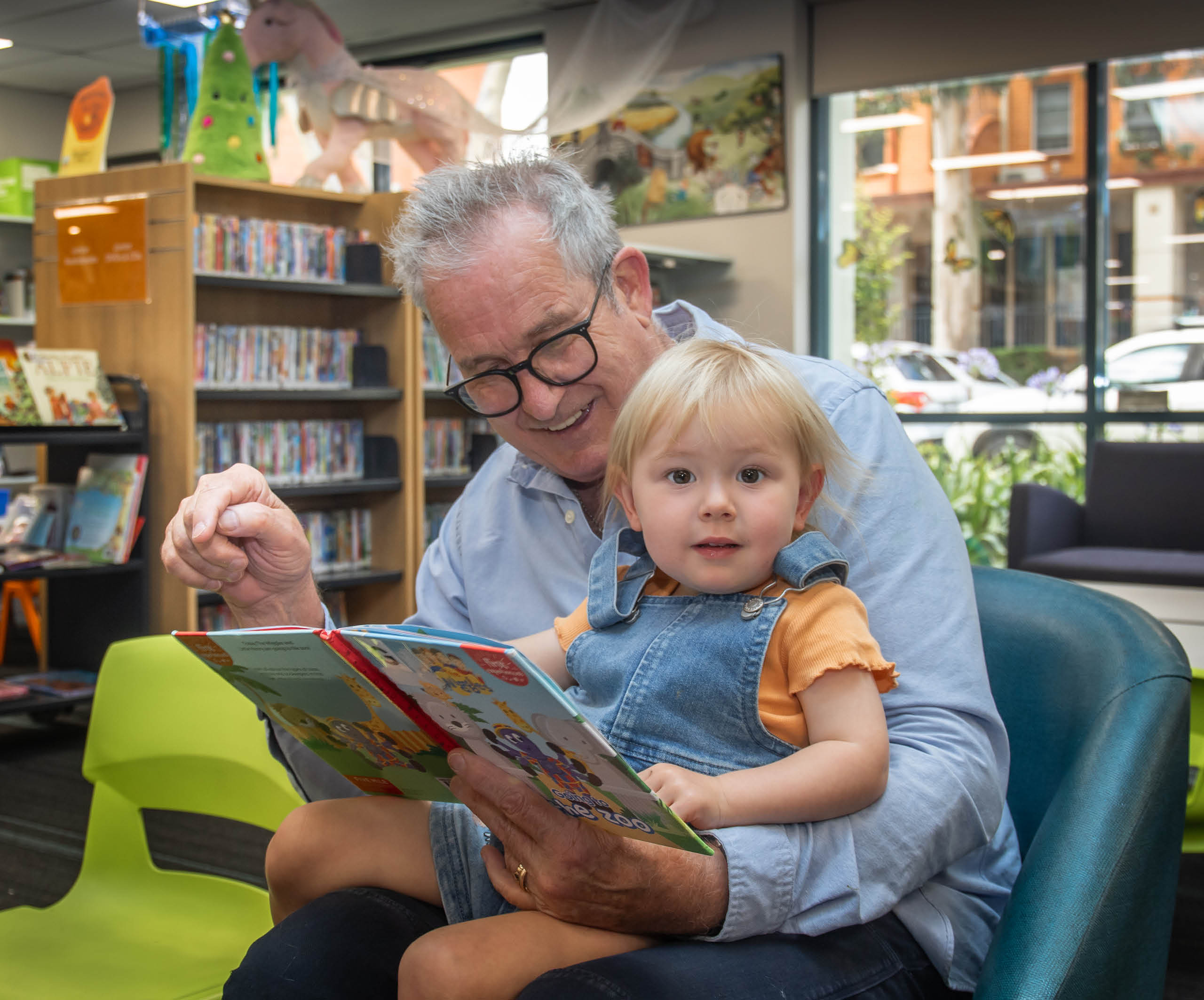grandfather with blonde toddler reading book