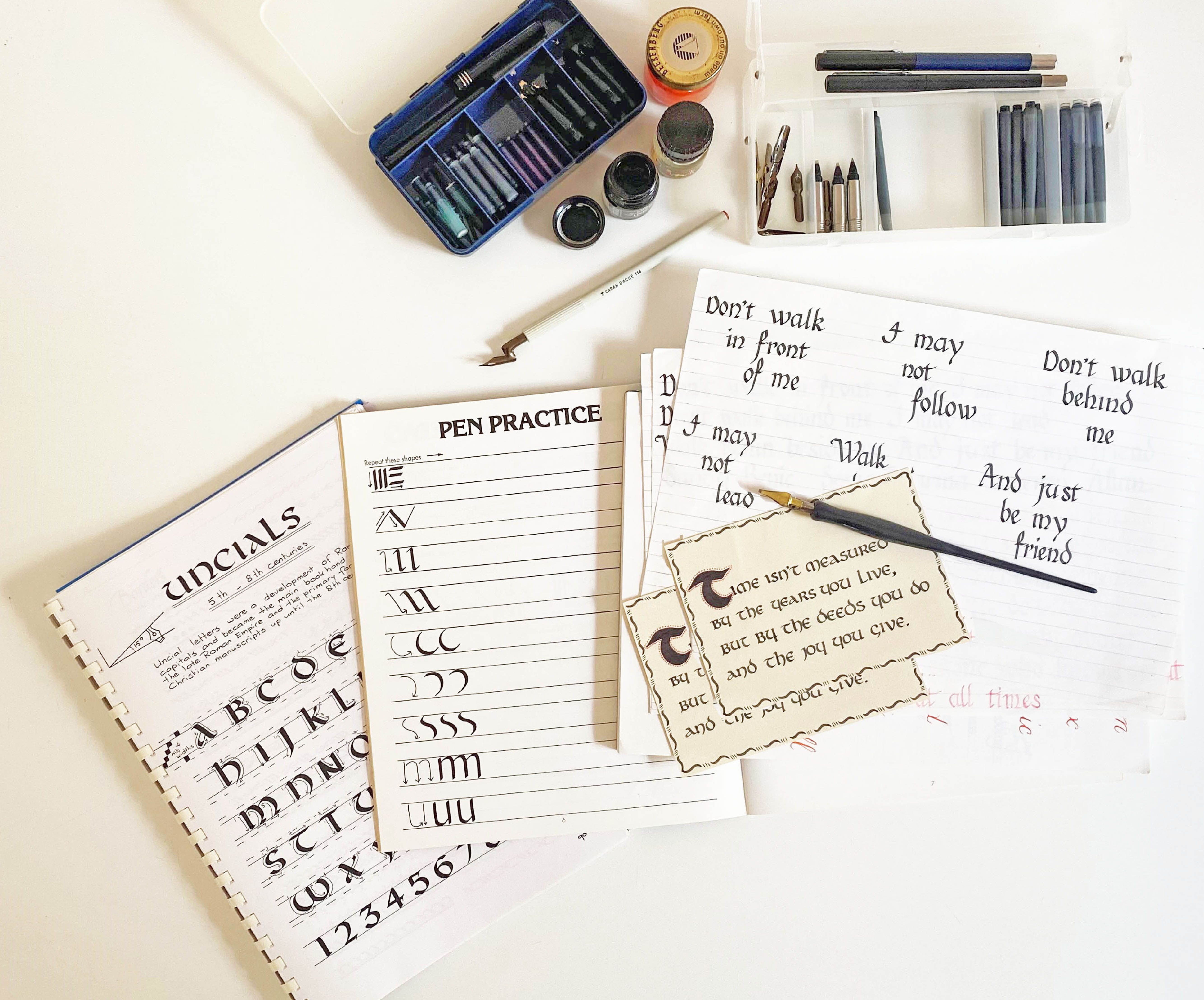 calligraphy pens, ink and sample writing flat lay