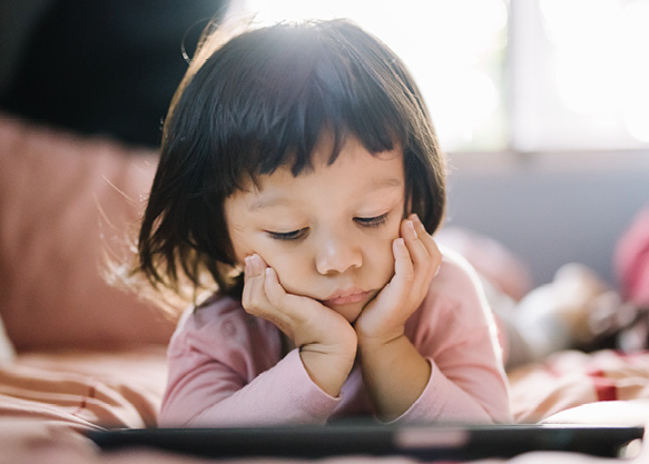 Young Asian girl reading iPad