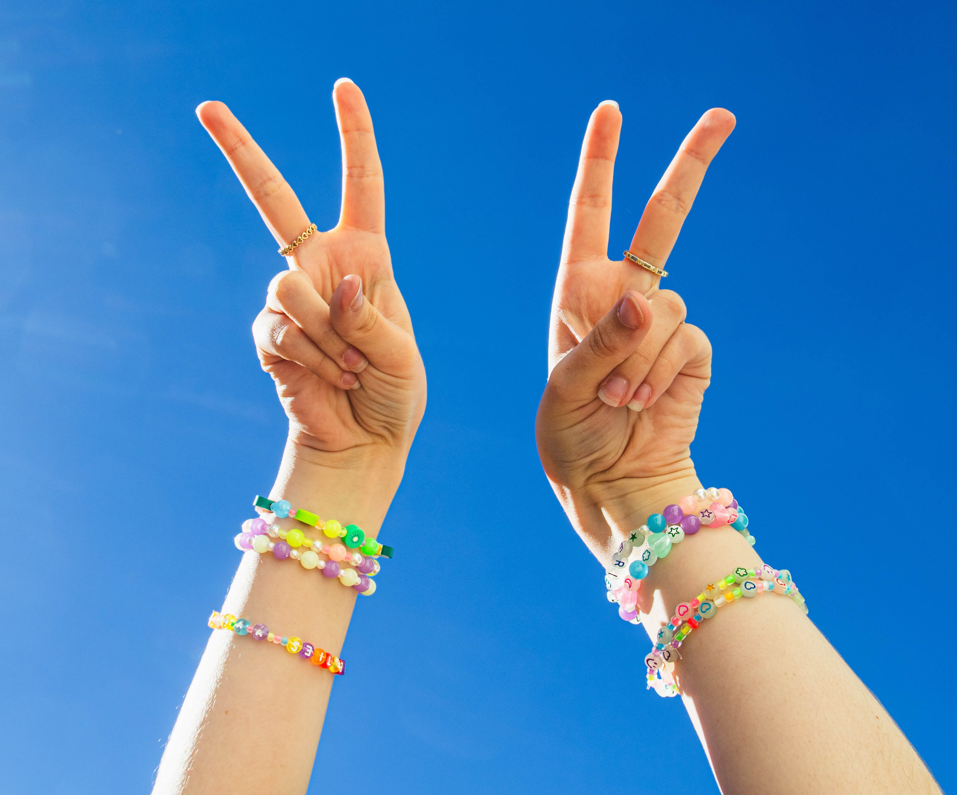 Arms in air wearing friendship bracelets 