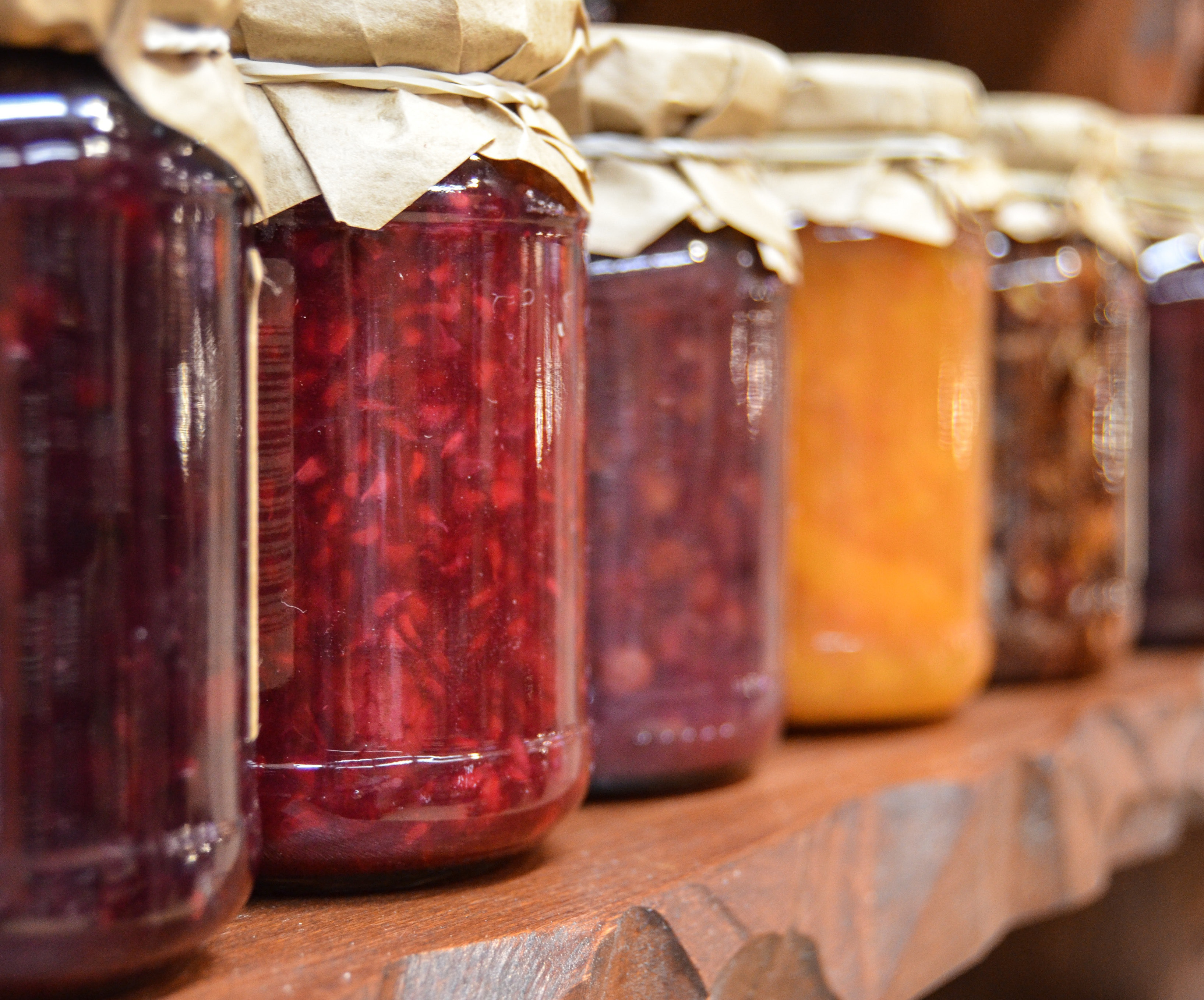 pickled food in jars on wooden shelf