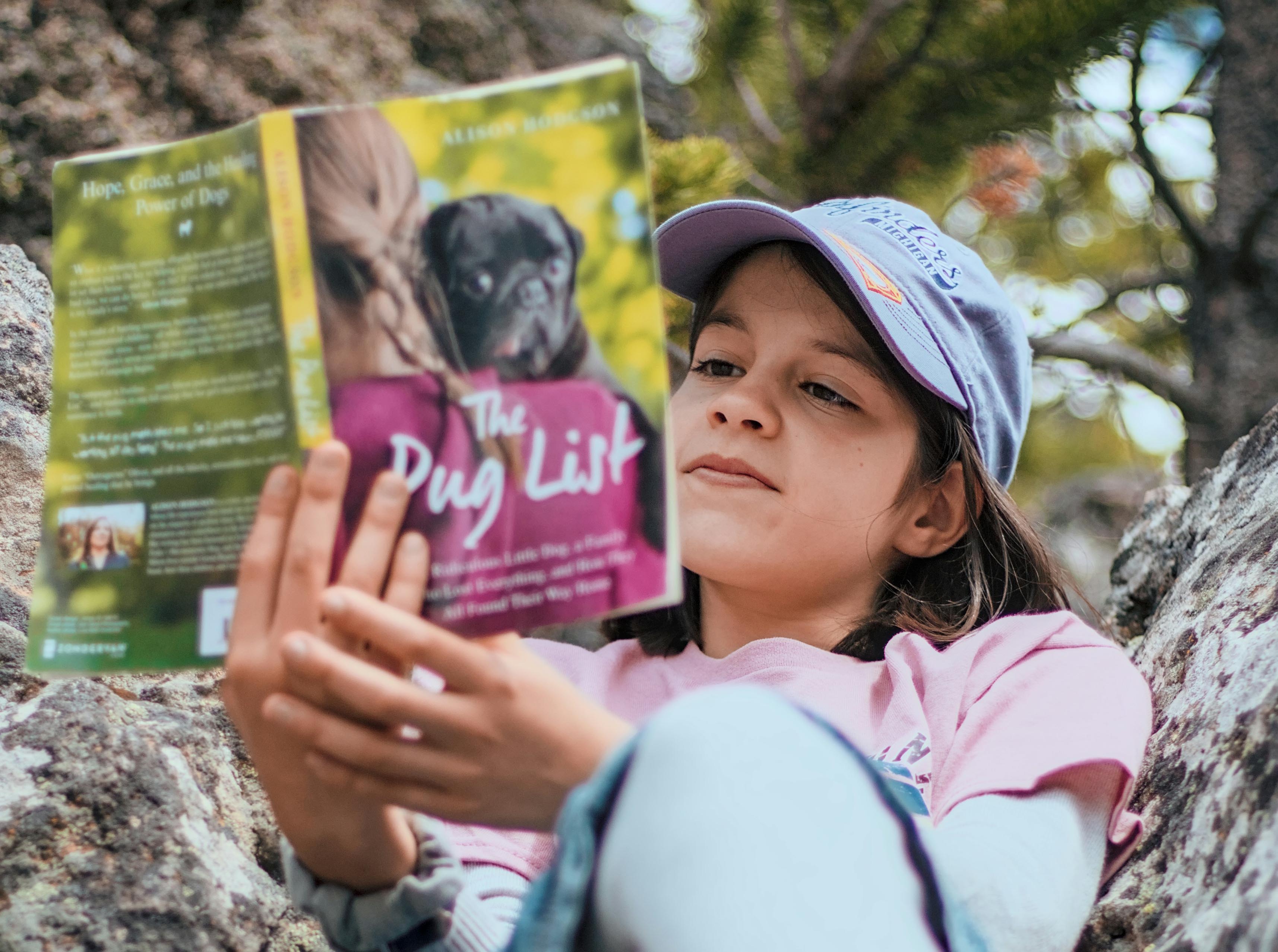 Young girl reading a book outdoors